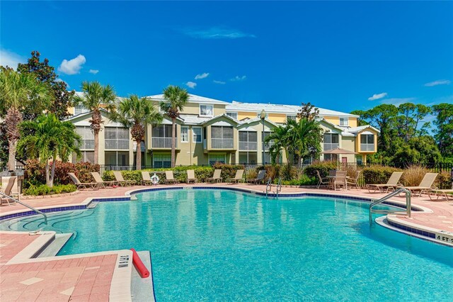 community pool featuring a patio and fence