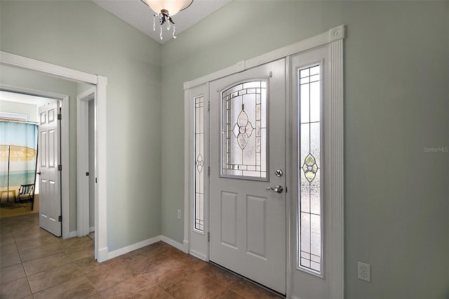 entrance foyer featuring dark tile patterned flooring and baseboards