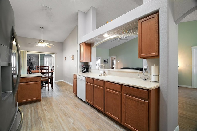 kitchen with a sink, ceiling fan, light wood-type flooring, stainless steel fridge, and dishwasher