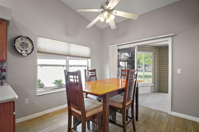 dining area featuring light wood-style floors, baseboards, and a ceiling fan