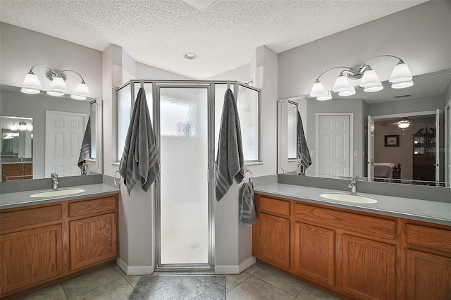 full bath with tile patterned flooring, a sink, and a shower stall