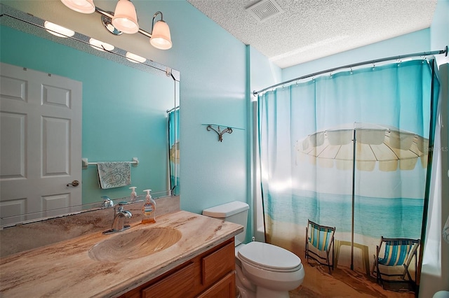 bathroom with visible vents, toilet, curtained shower, a textured ceiling, and vanity