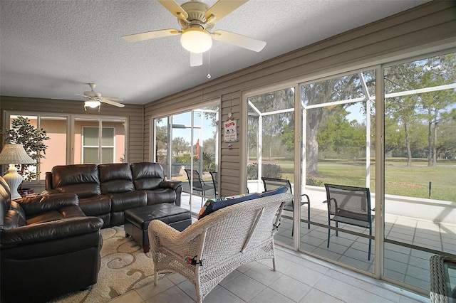 living room with light tile patterned floors, a textured ceiling, and a ceiling fan