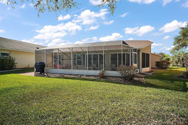 rear view of house with a yard and a lanai