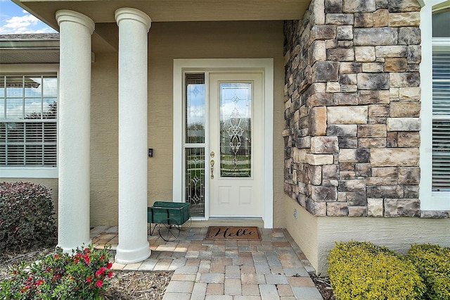 property entrance with stone siding and stucco siding