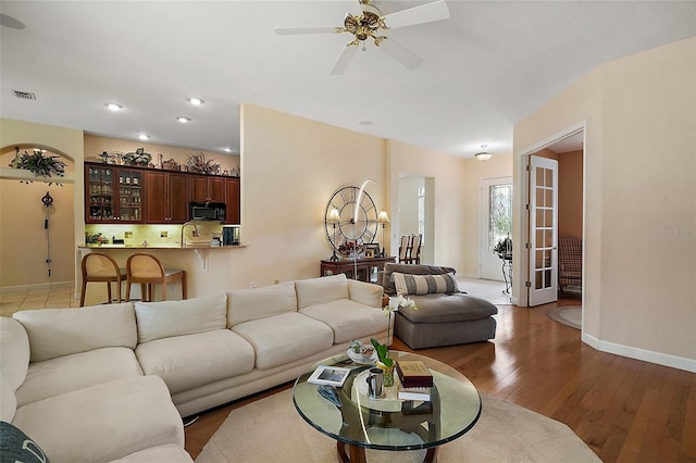 living area with visible vents, baseboards, a ceiling fan, light wood-style flooring, and recessed lighting