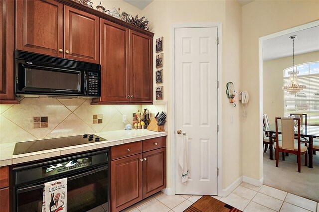 kitchen with black appliances, light tile patterned floors, decorative backsplash, and light countertops