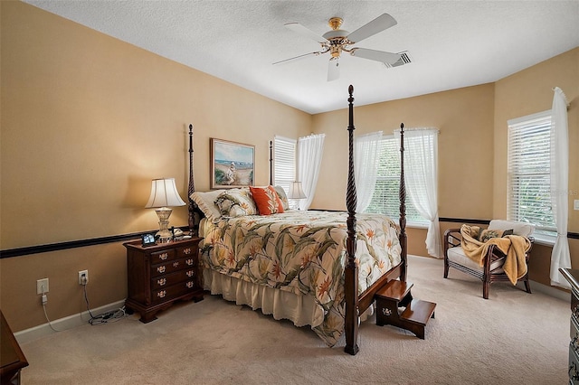 carpeted bedroom featuring visible vents, ceiling fan, a textured ceiling, and baseboards