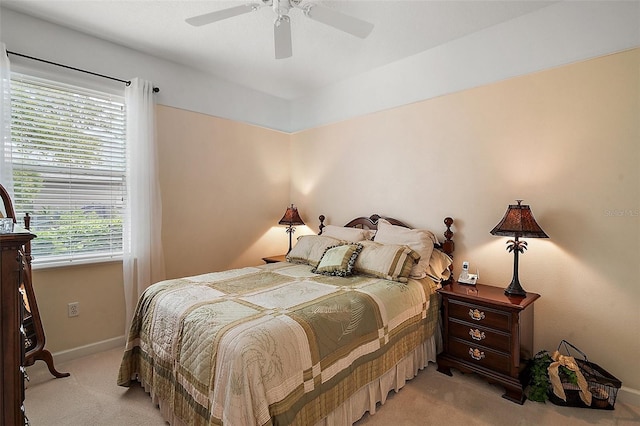 bedroom with light carpet, baseboards, and a ceiling fan