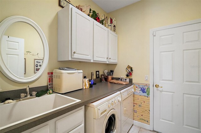 laundry area with light tile patterned floors, washer and clothes dryer, a sink, and cabinet space