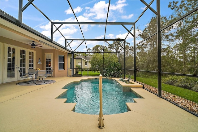 outdoor pool featuring glass enclosure, a ceiling fan, a patio, and french doors