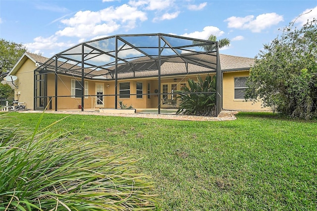 back of property featuring a lawn, a patio, and stucco siding