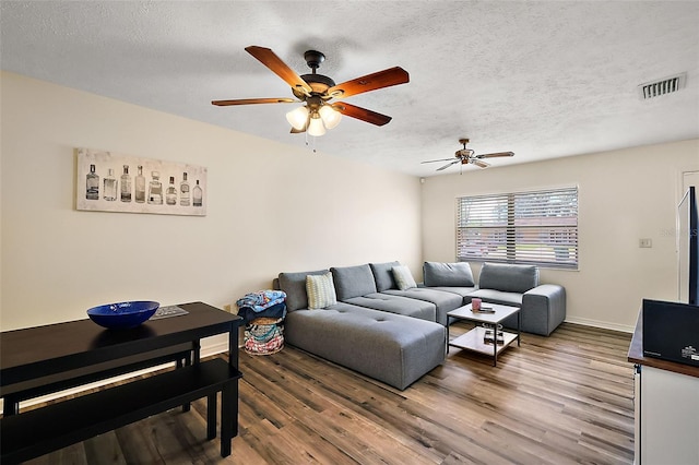 living room with a textured ceiling and wood finished floors