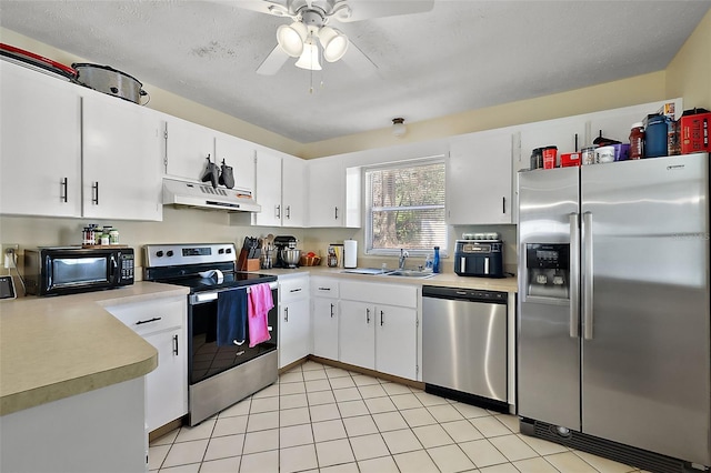 kitchen featuring light countertops, appliances with stainless steel finishes, white cabinets, a sink, and under cabinet range hood