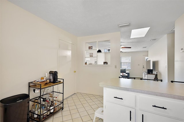 kitchen featuring light tile patterned floors, visible vents, light countertops, and a textured ceiling