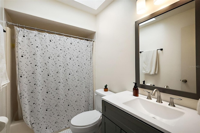 full bathroom featuring toilet, a skylight, curtained shower, and vanity