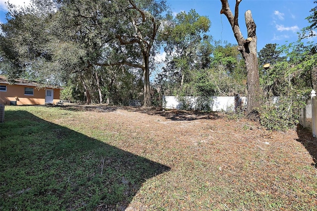 view of yard featuring fence and central AC