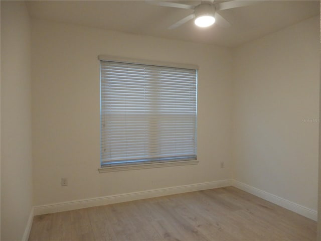 empty room featuring baseboards, light wood-type flooring, and ceiling fan