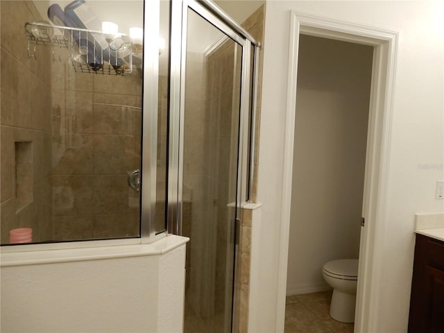 full bath with tile patterned floors, toilet, a stall shower, and vanity