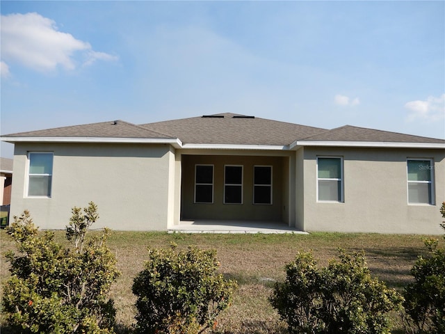 back of property with a patio area, roof with shingles, and stucco siding