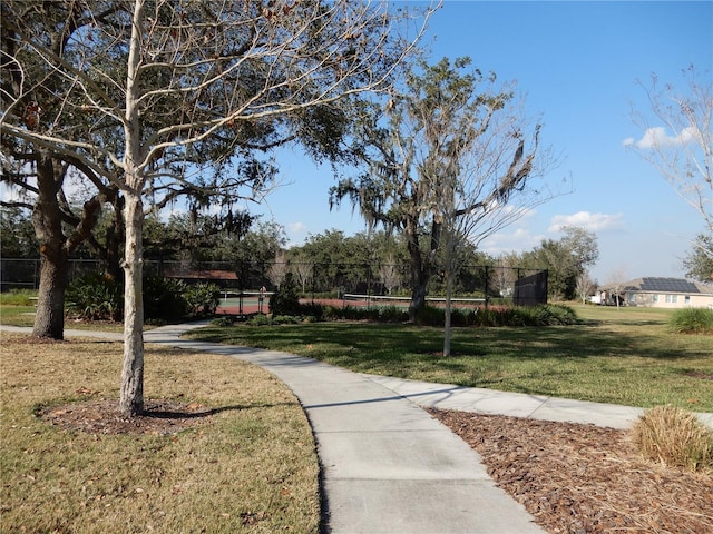 view of community featuring a yard and fence