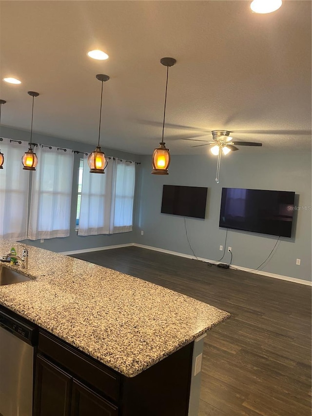 kitchen featuring a sink, light stone counters, dark wood finished floors, and dishwasher