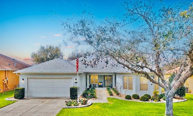 ranch-style house featuring stucco siding, a shingled roof, concrete driveway, an attached garage, and a front yard