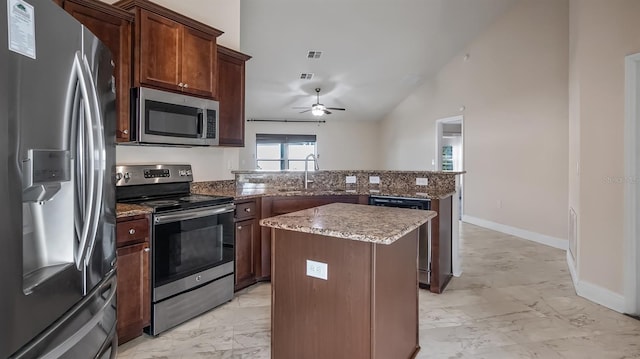 kitchen featuring a peninsula, a kitchen island, a sink, marble finish floor, and appliances with stainless steel finishes