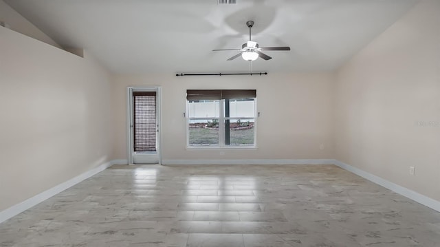 empty room featuring ceiling fan, visible vents, baseboards, and vaulted ceiling