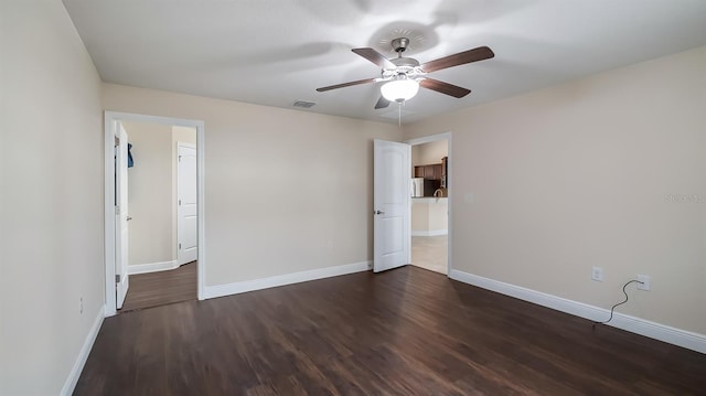 unfurnished bedroom with dark wood-style floors, ceiling fan, visible vents, and baseboards