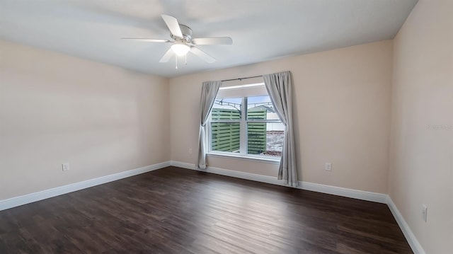 spare room featuring dark wood-type flooring, baseboards, and a ceiling fan