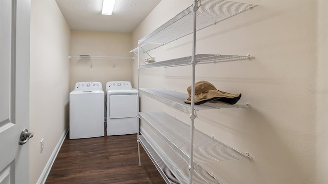 clothes washing area featuring laundry area, washer and clothes dryer, baseboards, and wood finished floors