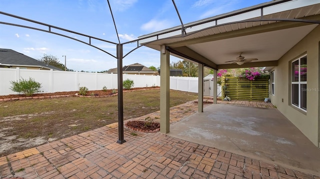 view of patio / terrace with ceiling fan, glass enclosure, and a fenced backyard