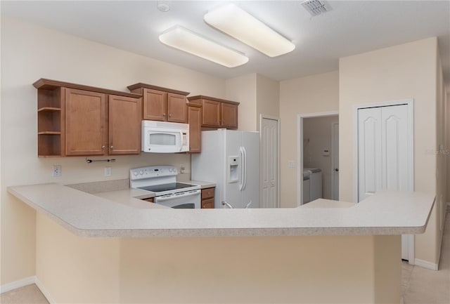 kitchen with open shelves, visible vents, brown cabinetry, washer and dryer, and white appliances