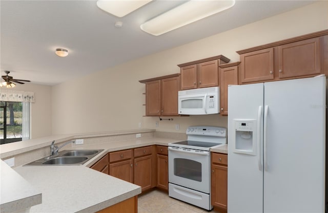 kitchen with brown cabinets, light countertops, a sink, white appliances, and a peninsula