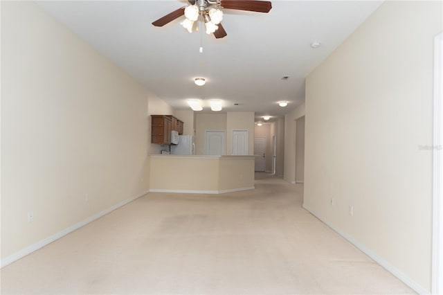 unfurnished living room featuring ceiling fan, light colored carpet, and baseboards