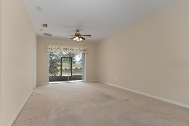 empty room featuring light carpet, ceiling fan, visible vents, and baseboards