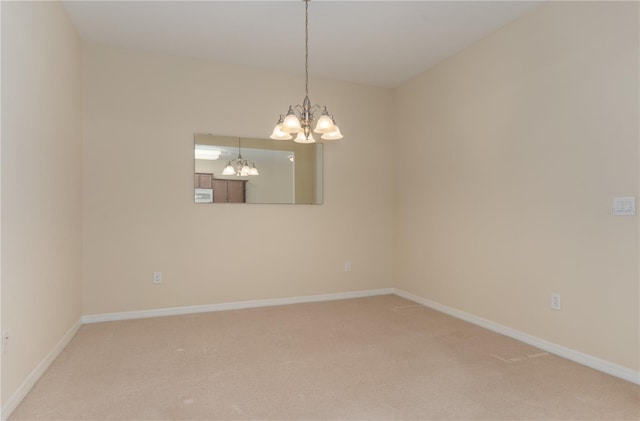 unfurnished room with light carpet, a chandelier, and baseboards