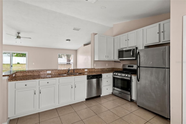 kitchen featuring stainless steel appliances, a sink, a wealth of natural light, and white cabinets