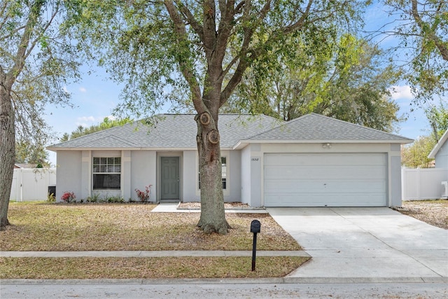 ranch-style house featuring an attached garage, driveway, fence, and stucco siding