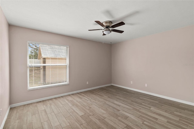 spare room with a ceiling fan, baseboards, and wood finished floors