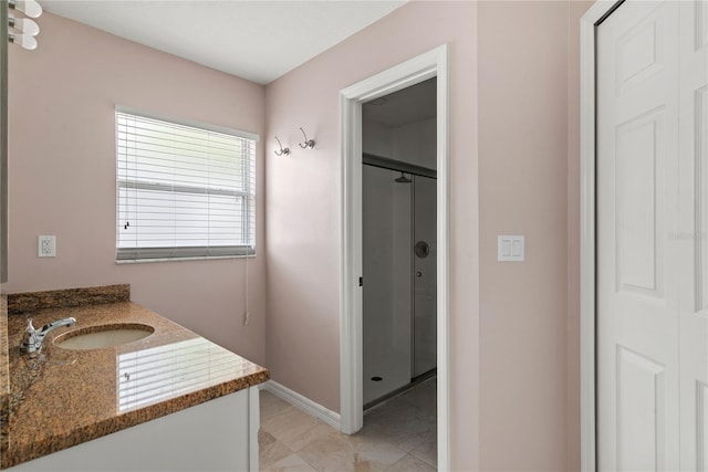 bathroom featuring a stall shower, vanity, and baseboards