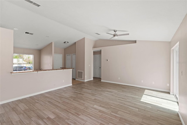 unfurnished living room with light wood-style flooring, visible vents, vaulted ceiling, and a ceiling fan