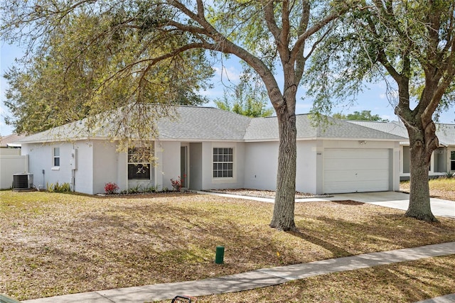 ranch-style house with a garage, concrete driveway, roof with shingles, cooling unit, and stucco siding