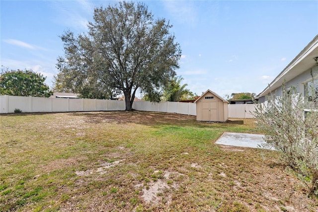 view of yard with an outbuilding, a fenced backyard, and a shed