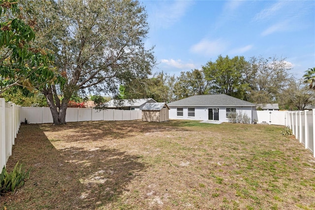 view of yard with a fenced backyard, an outdoor structure, and a shed