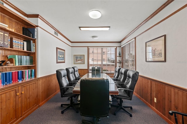 office space featuring wooden walls, a wainscoted wall, visible vents, ornamental molding, and carpet