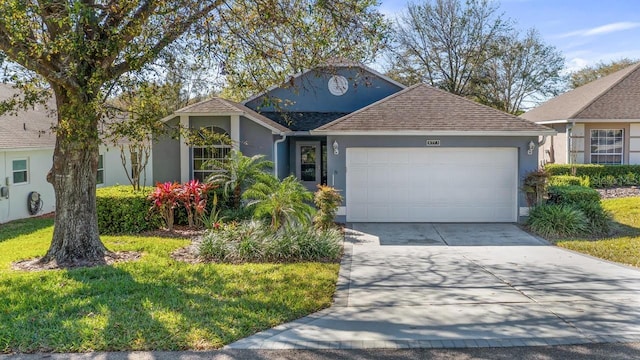 ranch-style home with a front lawn, roof with shingles, stucco siding, a garage, and driveway