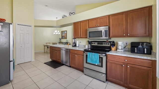 3773 Eversholt St, Clermont, FL 34711 - kitchen with light countertops, light tile patterned floors, brown cabinetry, and appliances with stainless steel finishes