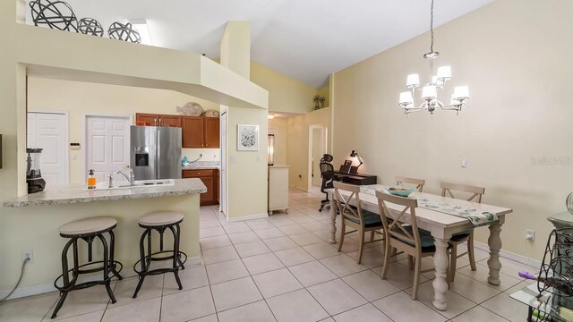 3773 Eversholt St, Clermont, FL 34711 - dining space with light tile patterned floors, baseboards, a notable chandelier, and high vaulted ceiling